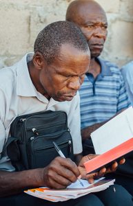 A man sitting taking notes from a Bible