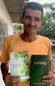 Hombre sosteniendo un libro y una Biblia