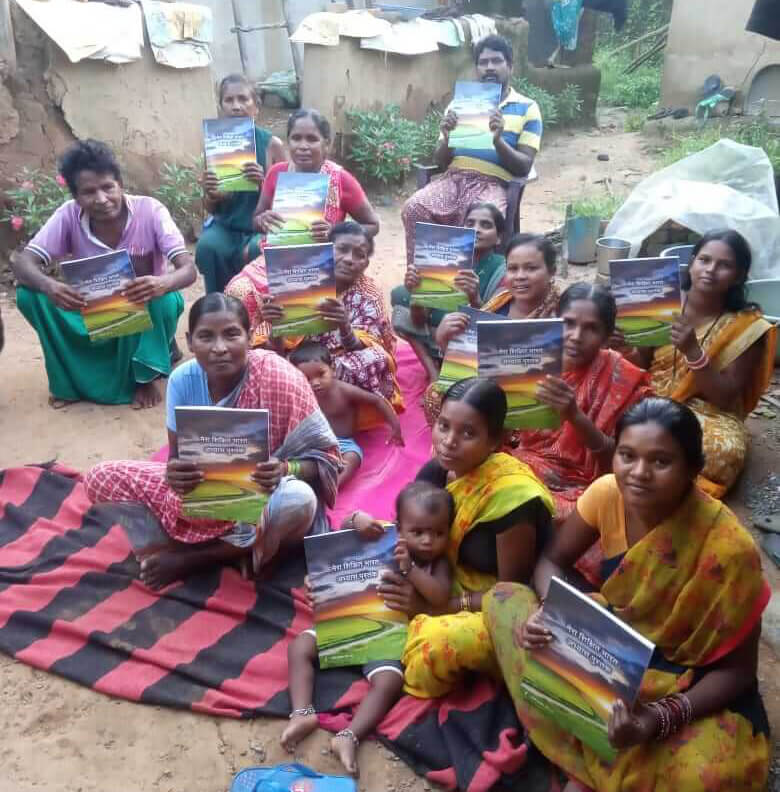Sapna and her community sitting holding books