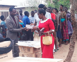 Joseph handing out Bibles to a group