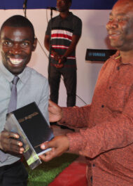 Reginaldo (izquierda) recibe una Biblia del pastor Jaime, Director Nacional.