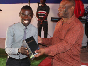 Reginaldo (izquierda) recibe una Biblia del pastor Jaime, Director Nacional.