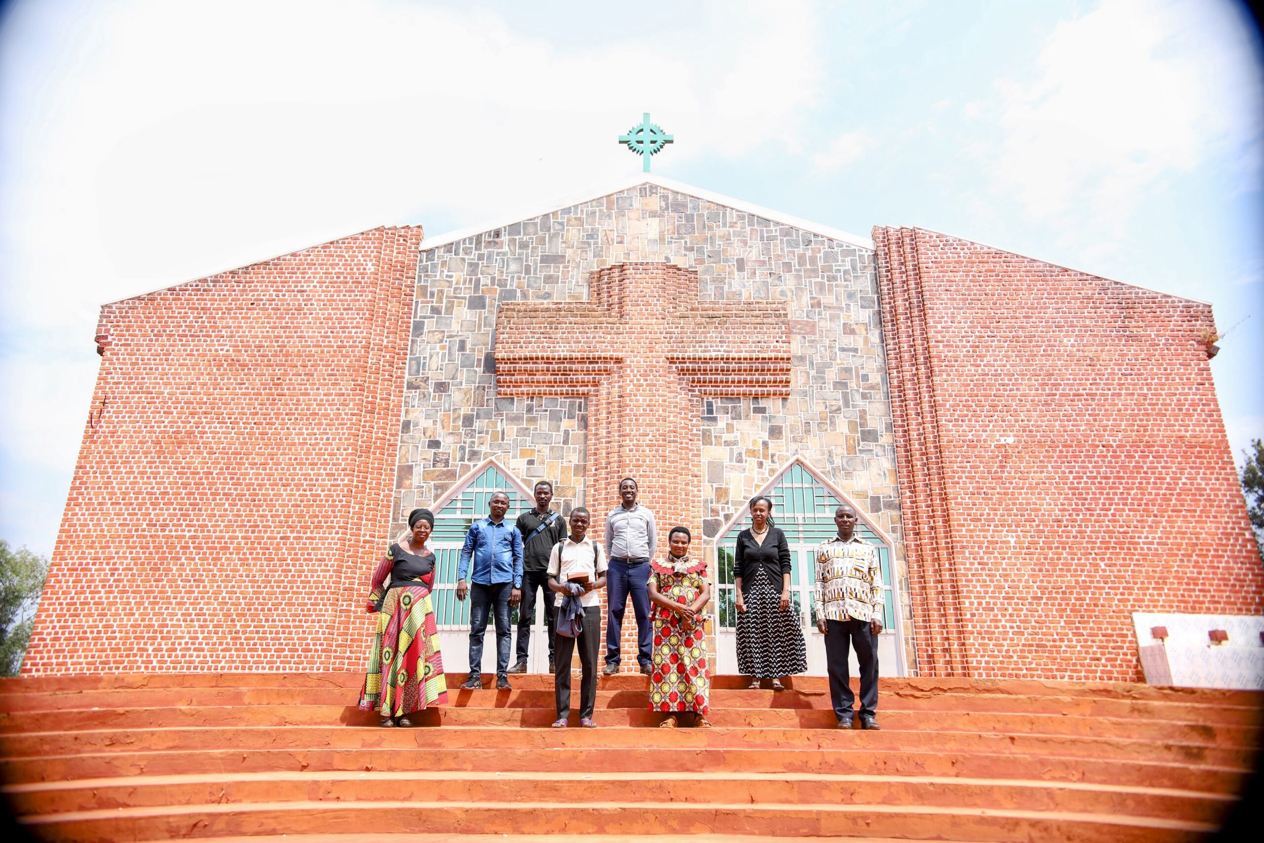 Happy Christ followers in Burundi standing in from of church, thankful for Bible League's effort to resource them. 