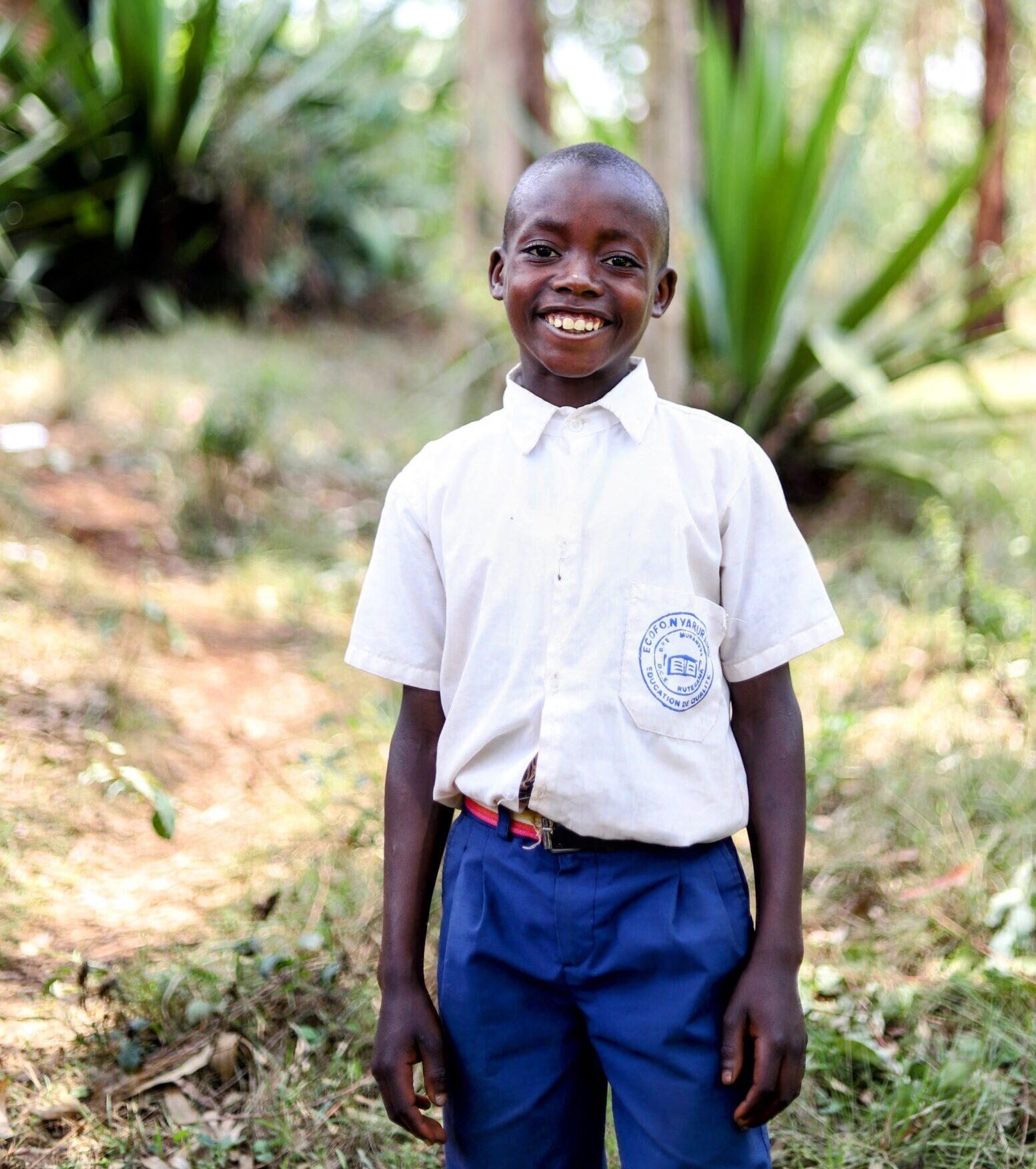 A Child from Burundi feeling happy for Bible League's help.