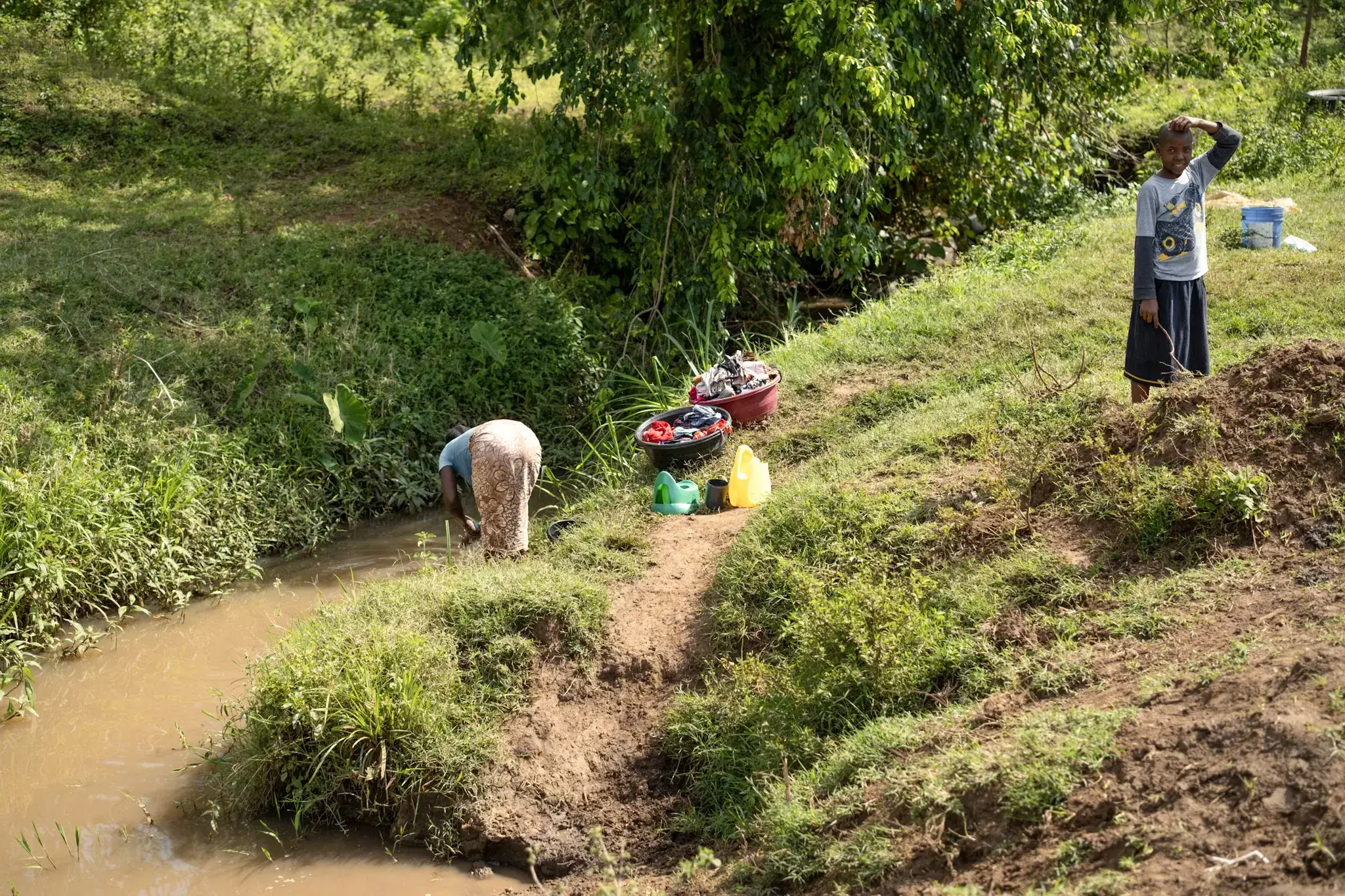 a small river. Pastor Mwita had pointed out that water is so scarce that the villagers bathe and wash their clothes in the same stream they drink from.